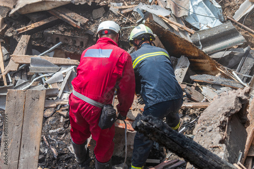 Obraz na plátně Rescue workers clearing debris at collapsed building site