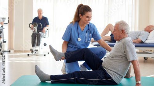 Young Physical Therapist Assisting Senior Man with Leg Exercise on Mat in a Rehabilitation Center