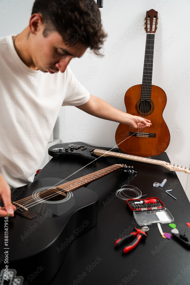 Obraz premium Installing new guitar strings. Musician installing a new string on an acoustic guitar. Acoustic guitar string replacement in progress. Guitarist stretches new strings onto the fretboard.