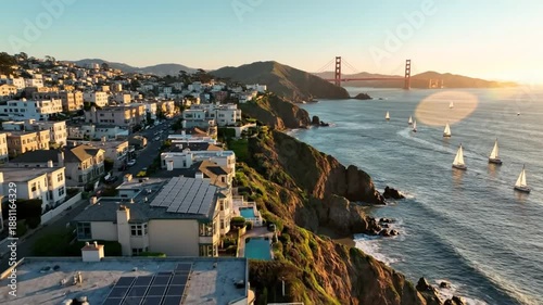 Coastal aerial view showcasing the Golden Gate Bridge, sailboats, and city in the warm sunset light