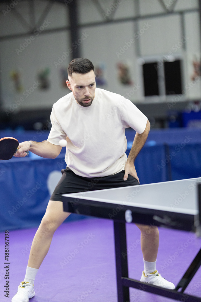 Fototapeta premium Man playing table tennis hitting ping pong ball