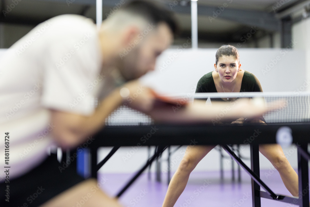 Fototapeta premium Young woman concentrating playing competitive table tennis