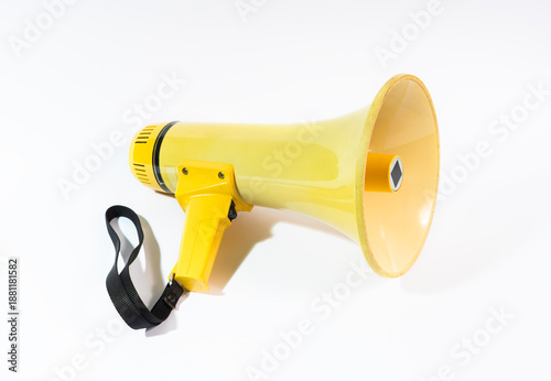 Yellow megaphone or bullhorn isolated on a white background. A portable loudspeaker with a black strap used for announcements, protests, and directing crowds