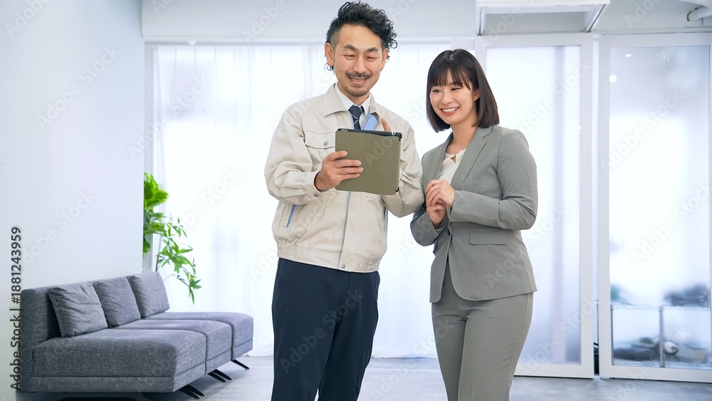 Fototapeta premium オフィスでタブレットを使って説明する作業員