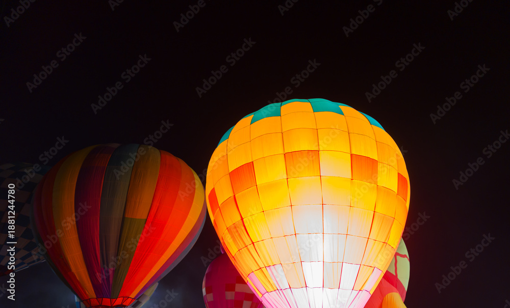 Fototapeta premium colorful hot air balloons glowing against dark night sky