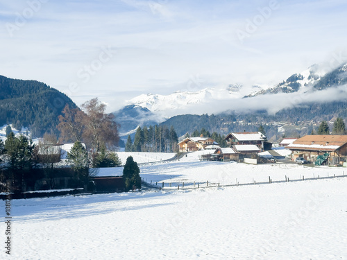 Beautiful early morning, snowy and foggy panorama shots of the Swiss Alps with saturated sun rays amidst early morning fog.  