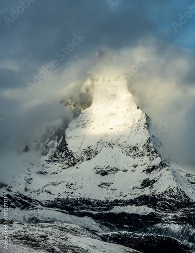 Sun Trying To Break The  Swirling Fog Over The Matterhorn