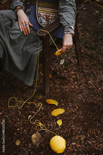 Cuadro en lienzo Close-up of hands with knitting needles, ball of yarn unraveling on the ground,