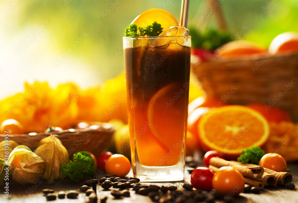 Fototapeta premium Iced Orange Espresso,Iced americano orange coffee in a glass decorated with fresh orange slice, cinnamon, and coffee beans on wooden table