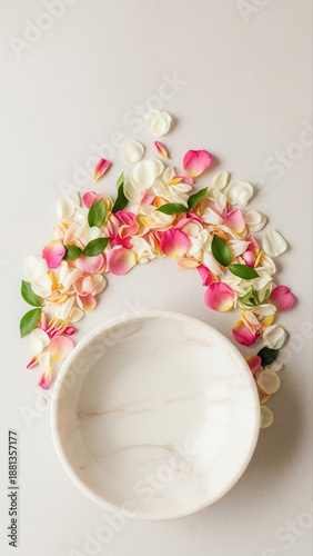 Elegant ceramic bowl surrounded by vibrant pink and white flower petals on a soft towel background, creating a serene and artistic composition