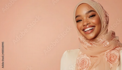 Beautiful young woman wearing a light colored embroidered head covering smiles brightly against a solid background