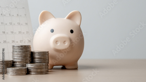 Billede på lærred Piggy bank with stacked coins and calendar background representing bill reminder, recurring payment schedule, monthly budgeting, expense tracking, and personal financial planning concept