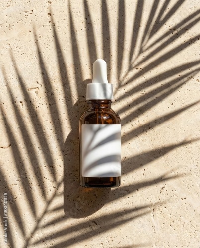 Vertical cosmetic serum bottle mockup with palm leaf shadow on beige stone. Summer skincare product background for social media stories.