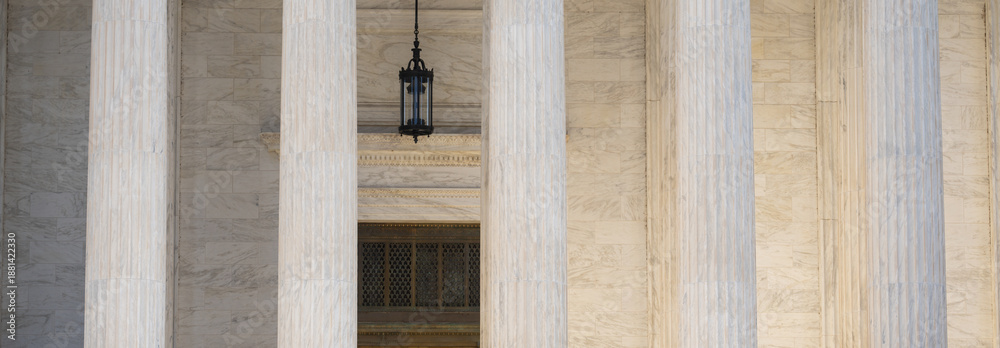 Fototapeta premium Government building with timeless columns. Classical facade with massive stone columns. Civic architecture expressed through marble pillars. Historic courthouse with monumental design.