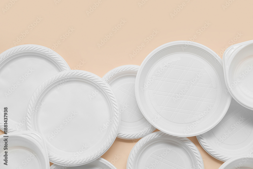 Fototapeta premium White plastic plates on beige background