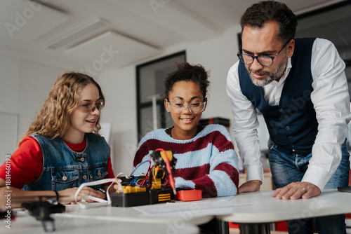 Photos High school students working on robotics project with their teacher