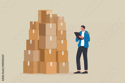 A man checking inventory of large stack of cardboard boxes in warehouse