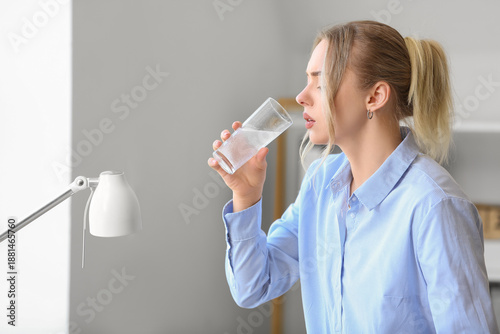 Young businesswoman drinkin...
