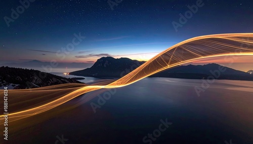 Wavy light trail streaks over lake, mountain range, under starry sky