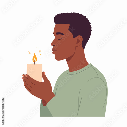 A man gently holding a lit candle with eyes closed in a moment of reflection