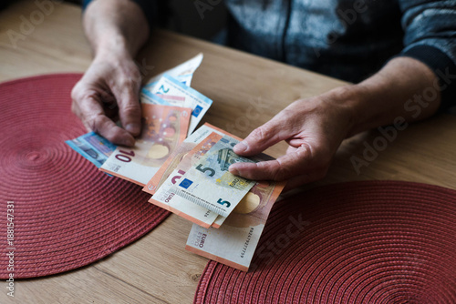 Slika na platnu A pensioner counts money, euro banknotes.