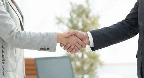 Close-up of professional business handshake between male manager and female colleague in bright modern office environment, diverse corporate partnership and successful deal agreement concept