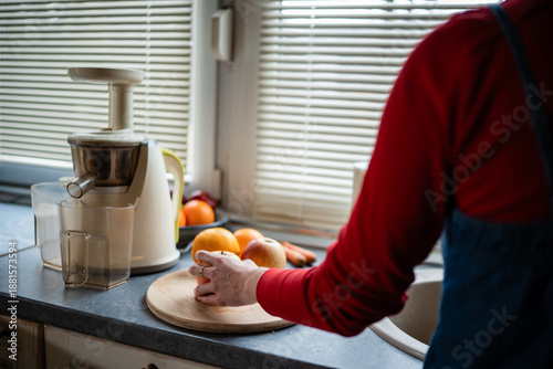 Person making healthy fresh juice with juicer