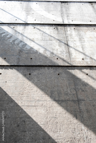 Concrete surface texture with lines and shadow pattern in sunlight creating minimal abstract background for modern architecture design and copy space