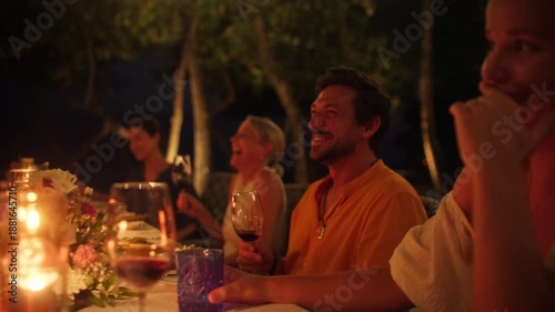 Happy friends and family enjoy a special evening dinner at a beautiful island resort