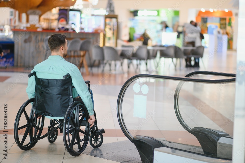 © Serhii - Man in wheelchair facing architectural barrier in shopping mall