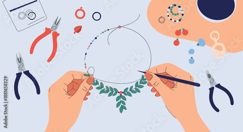 Top-down view of a jewelry maker's hands crafting a beautiful beaded necklace with pliers and other tools on a workbench.