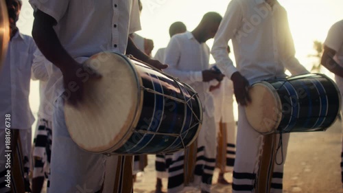 Traditional Bodu Beru drummers perform on tropical beach at sunset