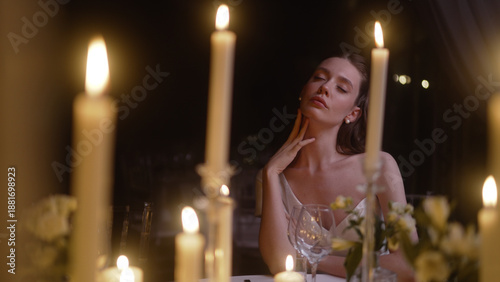 Tableau sur toile Beautiful woman sitting alone at a romantic candlelit dinner table