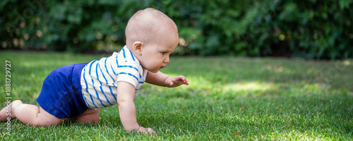 Obraz na plátne Cute little blond baby boy crawling fresh green grass