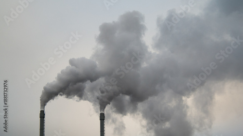 smoke coming from the factory chimneys against a gray sky