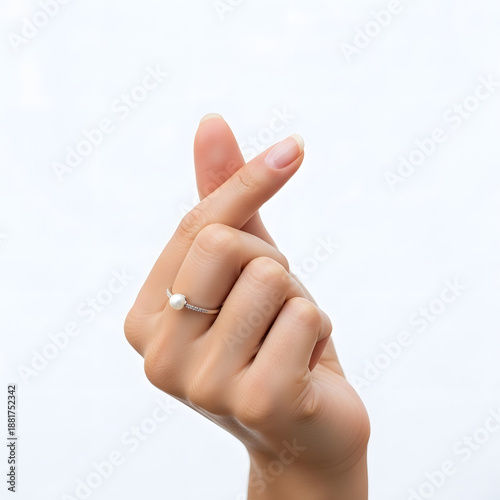 Close-up of Hand Making Korean Finger Heart Sign, Wearing Pearl and Diamond Ring
