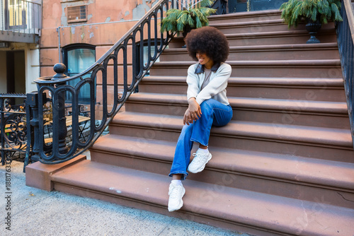 Fotografie Young woman enjoying urban lifestyle on stoop stairs