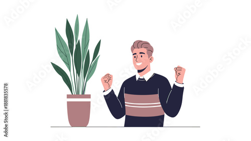 Happy young man celebrating a personal achievement or success with raised fists standing next to a green indoor plant.