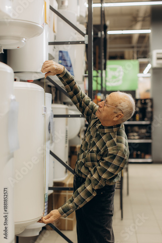 Photography Senior man measuring water heater dimensions in store