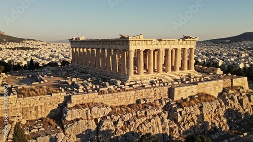 Ancient greek parthenon-style temple atop rocky hill overlooking athens skyline at sunset