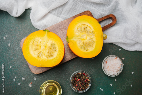 Canvas Print Fresh pumpkin halves on wood board with salt and pepper ready for cooking