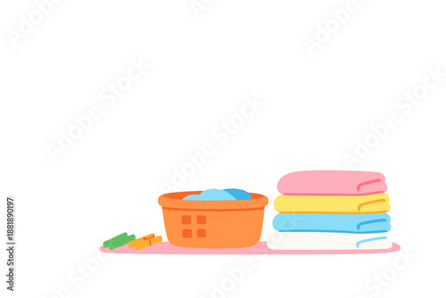 Colorful towels stacked next to a laundry basket with clean clothes