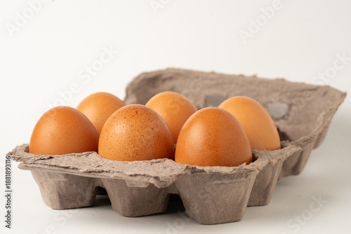 Six eggs in a cardboard carton isolated on white