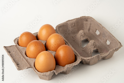 Eggs neatly arranged in a cardboard carton on a white background