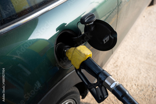 Foto Close-up of a green compact car being refueled at a gas station