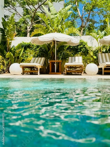 Cuadro en lienzo Sunny view of luxury sun loungers and parasol from water