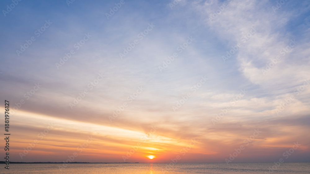 Obraz premium Sunset sky cloud sea water background in golden evening with orange, blue sun light,Horizon sea ocean sunrise sky landscape nature backgrounds warm gold sun down in golden hour summer season,Dusk sky