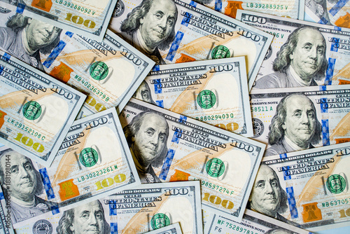American bills of 100 US dollars are laid out on the surface and occupy the entire area of ​​the image, the background is made of American dollars, greenbacks of large denominations