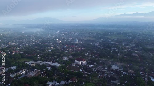 Wallpaper Mural Aerial view of a city with RInjani mountain in the background under cloudy skies. Torontodigital.ca