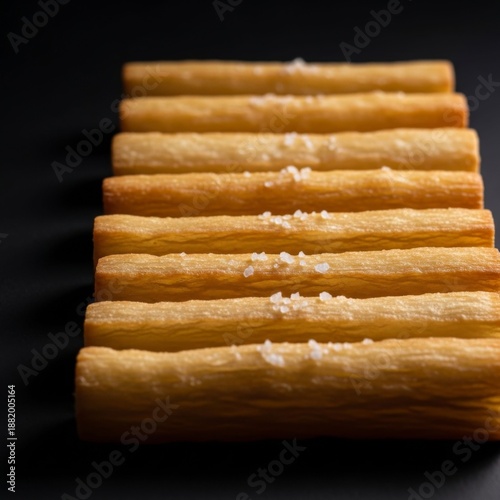 Golden Baked Breadsticks with Sea Salt Flakes on Dark Background